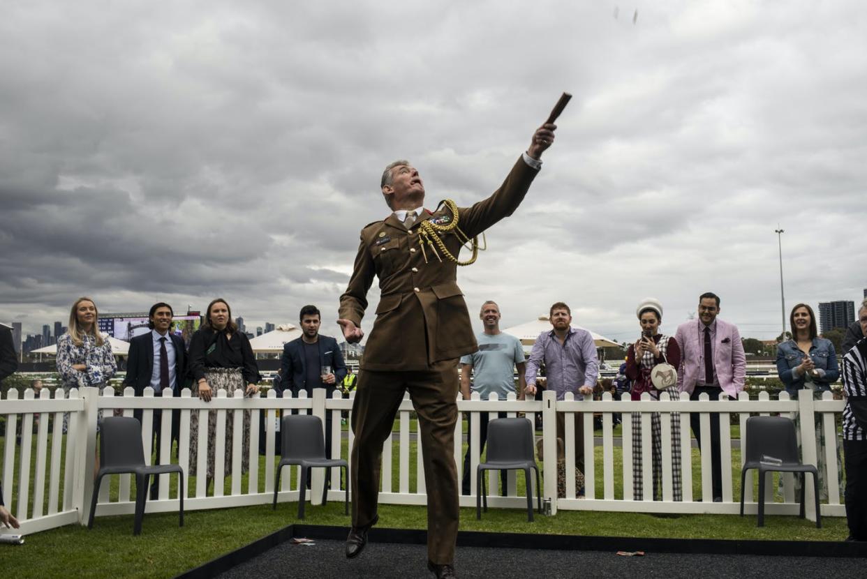 <span class="caption">Spinner tosses the penny during a Two Up game at Flemington Racecourse during the Anzac Day in Melbourne in 2021.</span> <span class="attribution"><span class="source"> Diego Dedele/ AAP</span></span>