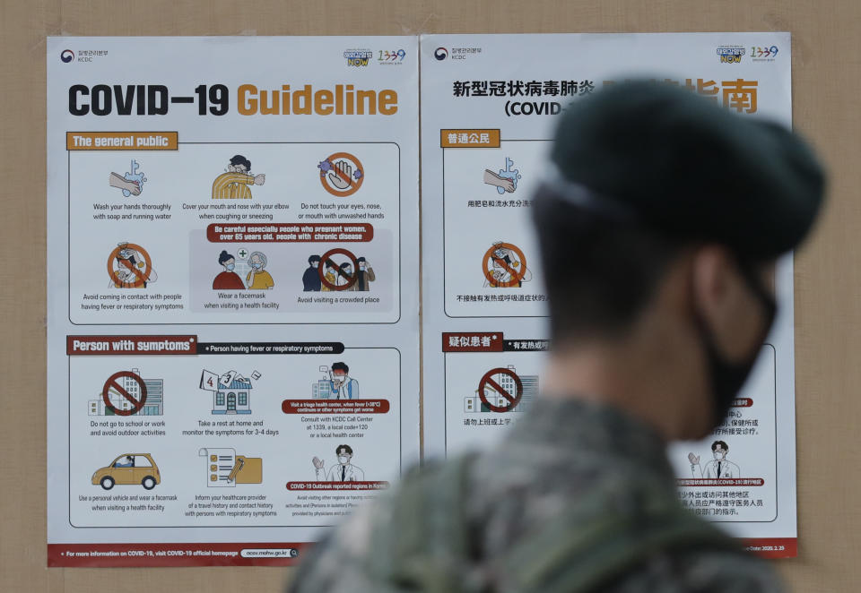 A South Korean soldier wearing a face mask walks near banners showing precautions against the new coronavirus in Seoul, South Korea, Wednesday, June 17, 2020. (AP Photo/Lee Jin-man)