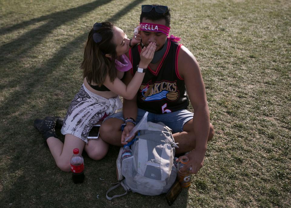 Tran Dang (left) rubs sunscreen on the nose of Kenny Ravelo (right) at the Coachella Valley Music and Arts Festival in Indio, Calif., on Sunday, April 14, 2019.