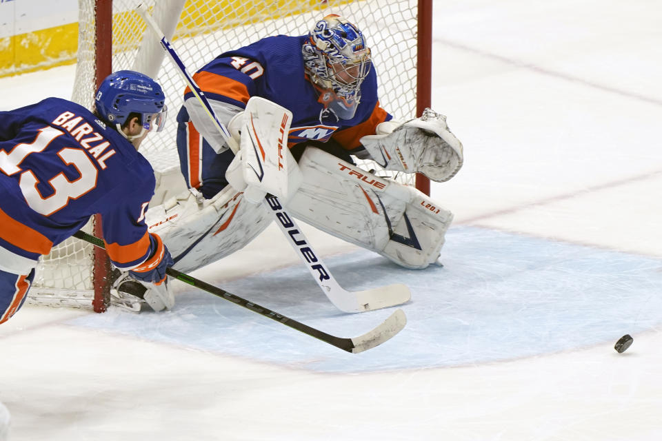 New York Islanders center Mathew Barzal (13) and goaltender Semyon Varlamov (40) defend against the Washington Capitals during the first period of an NHL hockey Thursday, April 22, 2021, in Uniondale, N.Y. (AP Photo/Kathy Willens)