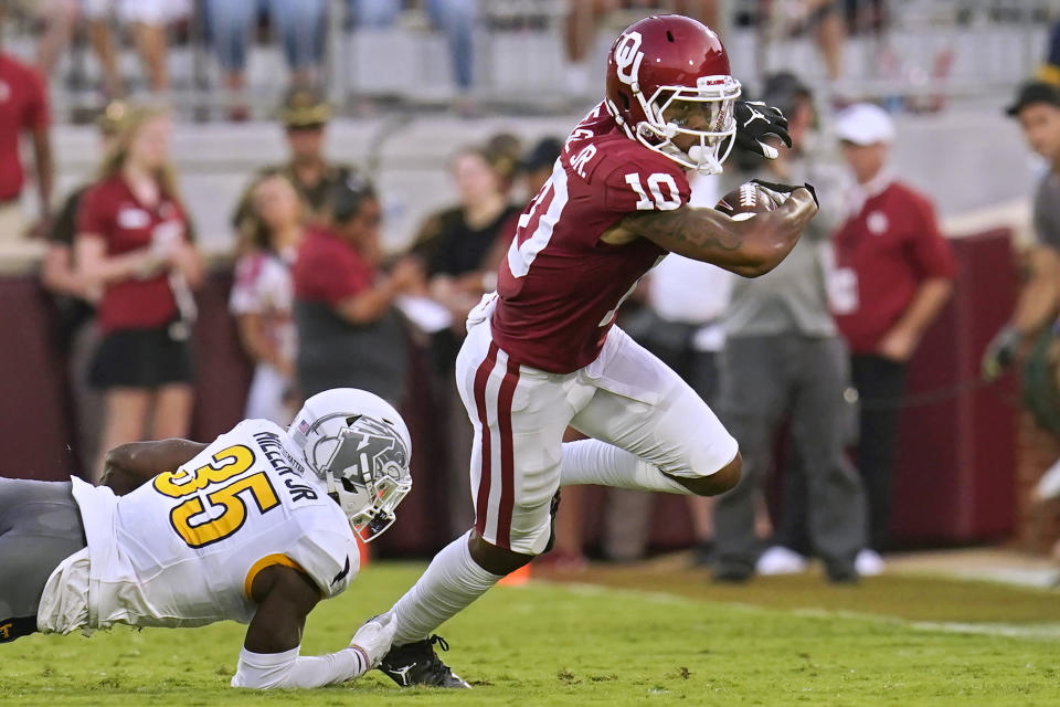 Oklahoma wide receiver Theo Wease (10) avoids a tackle by Kent State defensive back D.J. Miller Jr. (35) during the first half of an NCAA college football game Saturday, Sept. 10, 2022, in Norman, Okla. (AP Photo/Sue Ogrocki)