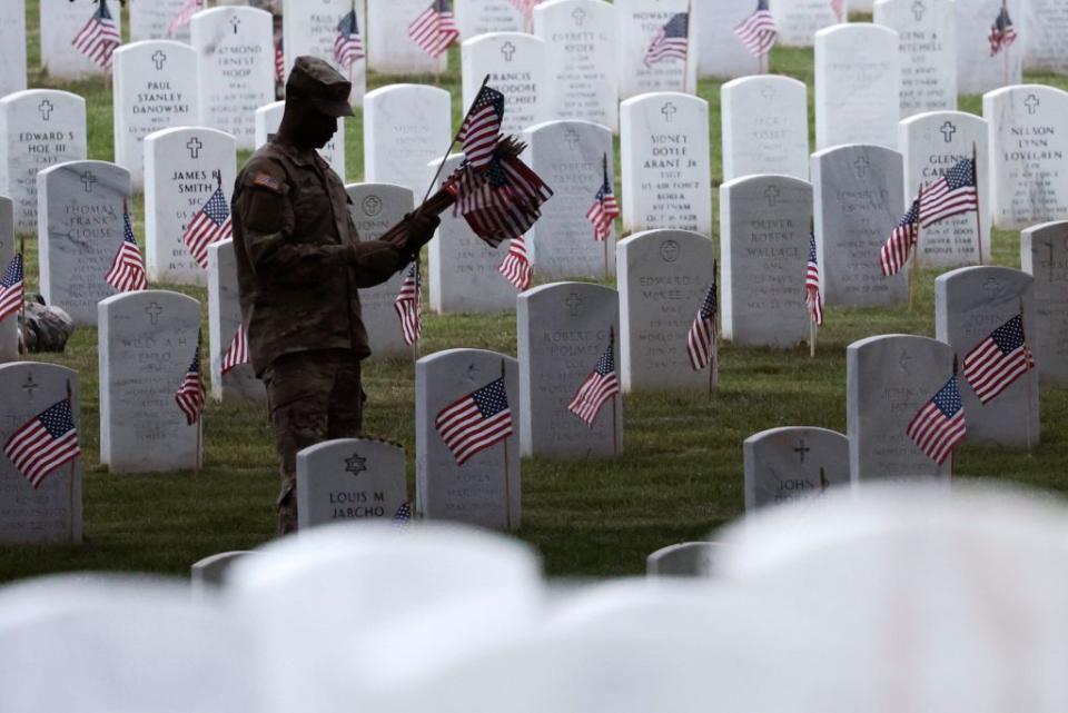 ARLINGTON, VIRGINIA - MAY 25: Members of the 3rd U.S. Infantry Regiment place flags at the headstones of U.S. military personnel buried at Arlington National Cemetery, in preparation for Memorial Day, on May 25, 2023 in Arlington, Virginia. More than 1000 service members entered the cemetery at pre-dawn hours to begin the process of placing a flag in front of more than 270,000 headstones. (Photo by Win McNamee/Getty Images)