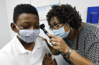 Dr. Janice Bacon, a primary care physician with Central Mississippi Health Services, gives Jeremiah Young, 11, a back-to-school physical, at the Community Health Care Center on the Tougaloo College campus, in Tougaloo, Miss., on Aug. 14, 2020. As a Black primary care physician, Bacon has created a safe space for her Black patients during the coronavirus pandemic. (AP Photo/Rogelio V. Solis)