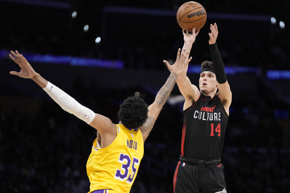 Miami Heat guard Tyler Herro, right, shoots as Los Angeles Lakers forward Christian Wood defends during the second half of an NBA basketball game Wednesday, Jan. 3, 2024, in Los Angeles. (AP Photo/Mark J. Terrill)