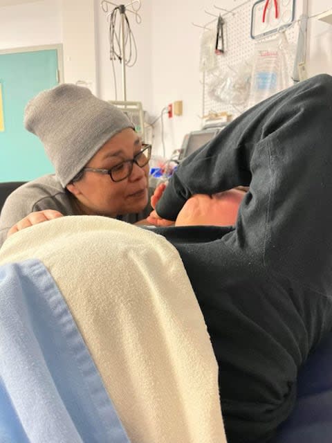 Wilma comforting her daughter Kaysha, who is crying. Kaysha got into a snowmobile accident that left her pelvis broken, but she didn't receive medevac. Wilma is singing 'You Are My Sunshine' to her. (Submitted by Wilma Jenkins - image credit)