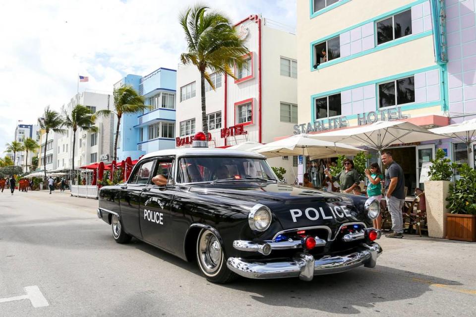 A classic Miami Beach Police patrol car is driven down Ocean Drive during the annual Veterans Day parade in 2021.