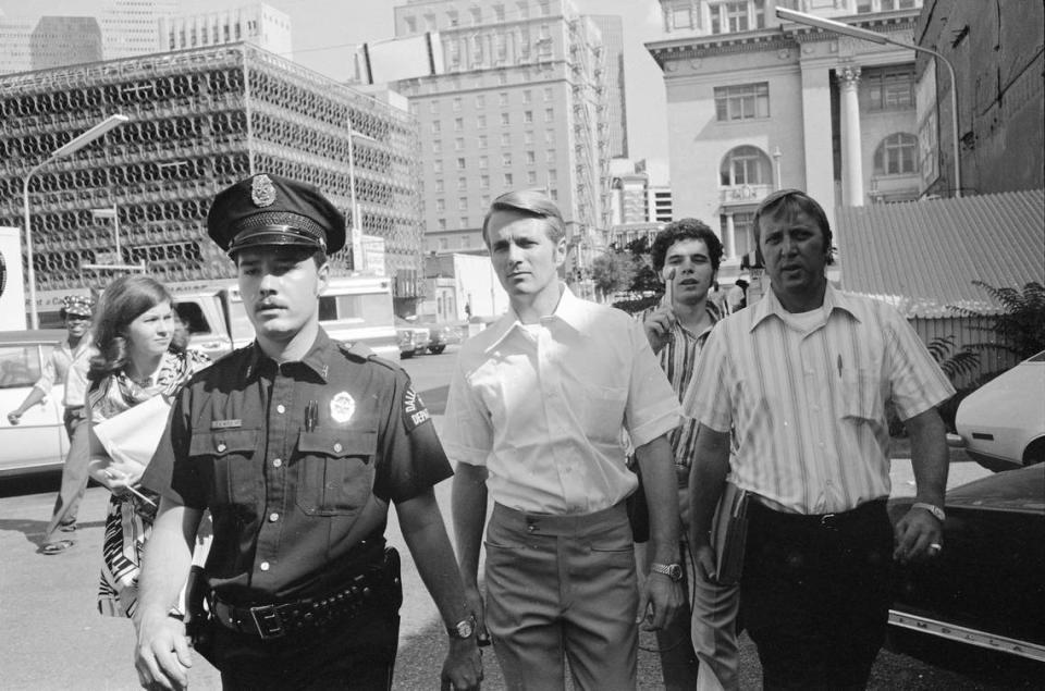 Darrell Lee Cain, the Dallas police officer who shot and killed Santos Rodriguez, and his attorney Phil Burleson walk on Dallas Street with a police escort on July 24, 1973. Courtesy/Dallas History & Archives Division, Dallas Public Library