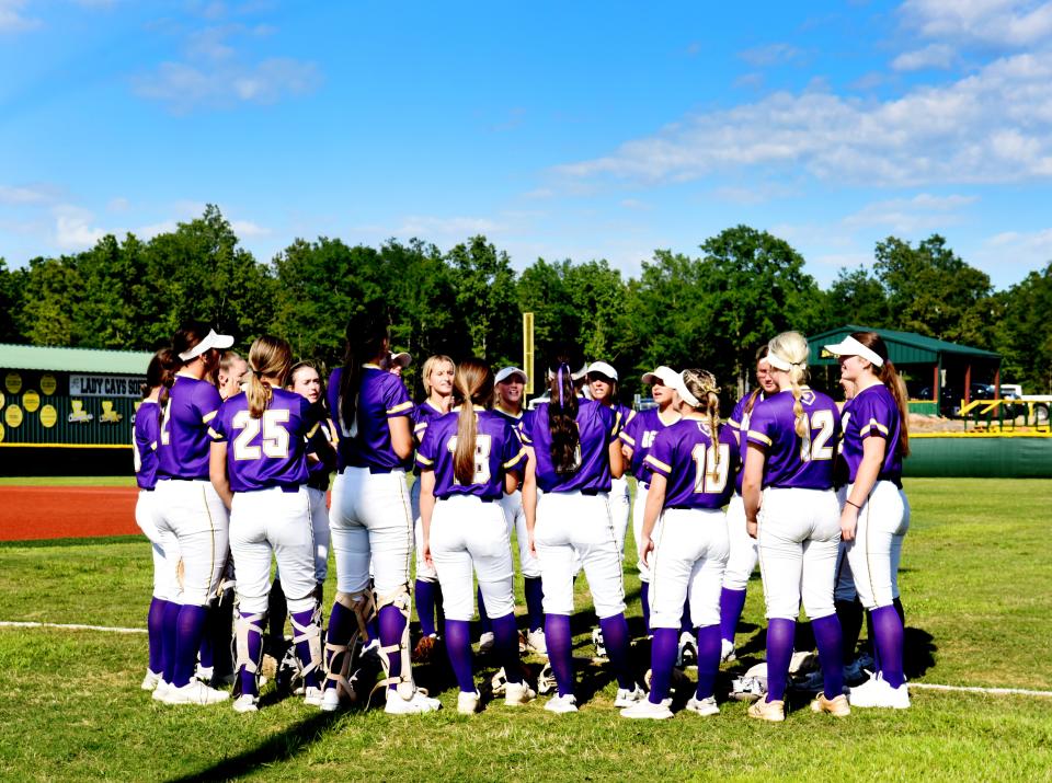 Benton softball players huddle on the field on April 11, 2023.