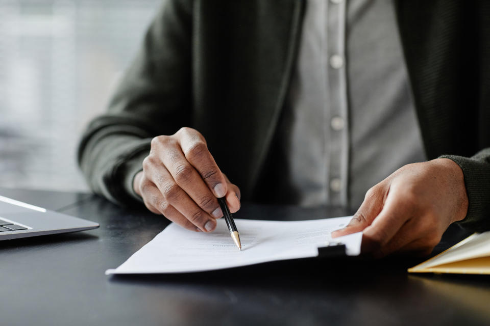 man looking over a resume with a pen