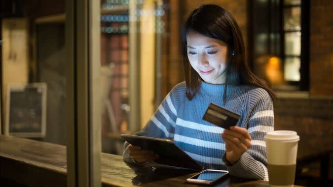 woman using tablet while shopping with credit card