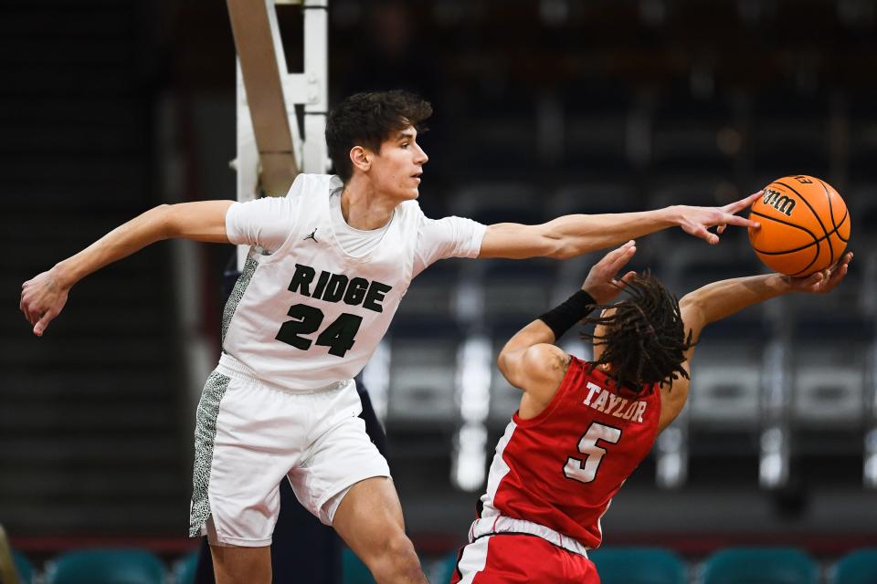 Fossil Ridge boys basketball player Colin Hayes (24) blocks a shot from Damarius Taylor (5) in a 6A Final 4 playoff game against Regis at the Denver Coliseum on March 10.