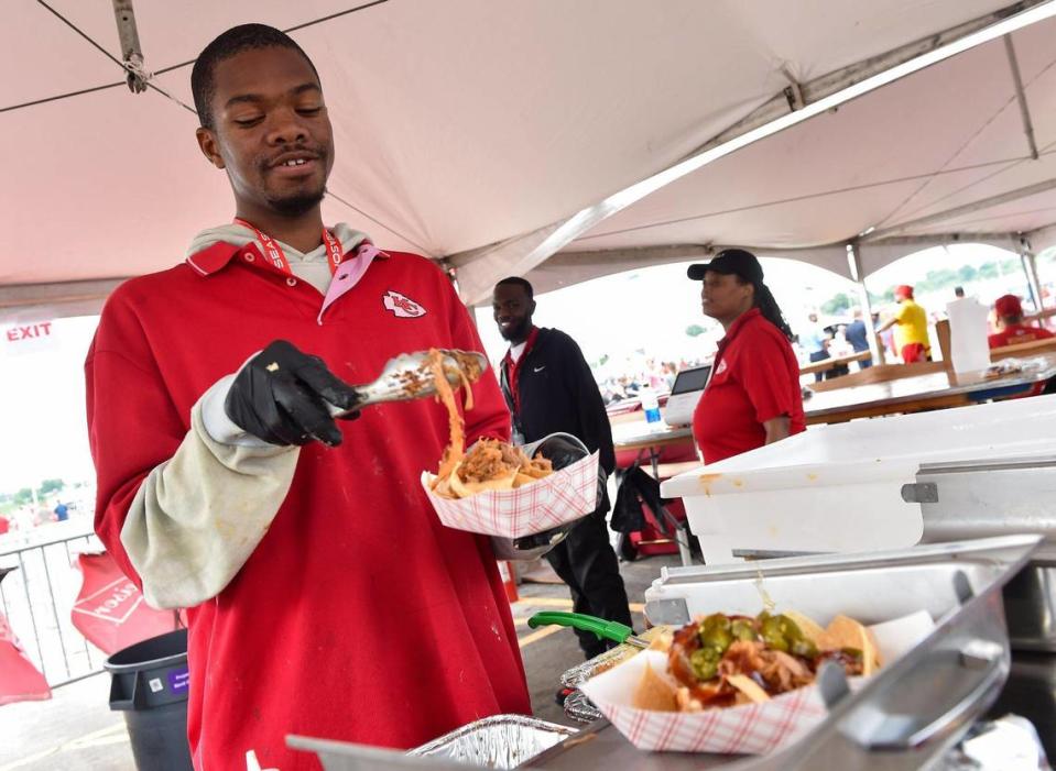 Jerrell Stevens prepares orders of pulled pork nachos at the Plowboys Barbeque booth. The three-day Kansas City BBQ Festival in the parking lot of the GEHA Field at Arrowhead Stadium concluded Sunday, July 11, 2021.