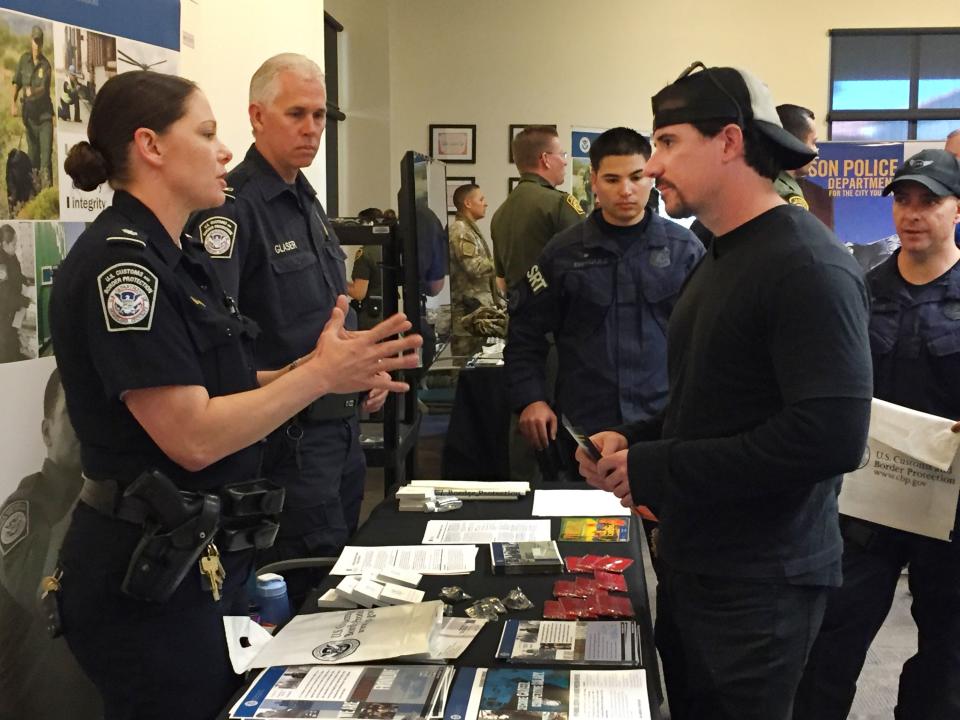 U.S. Customs and Border Protection recruiter Kelly Ursu talks with Michael Hamilton, a 28-year-old criminal justice degree graduate of Northern Arizona University who is considering applying for a job with the agency at a job fair at Pima Community College in Tucson, Ariz., Monday, Nov. 9, 2015. U.S. Customs and Border Protection is pushing to close a staffing shortage at Arizona ports of entry that business leaders say negatively impacts trade and commerce. (AP Photo/Astrid Galvan)