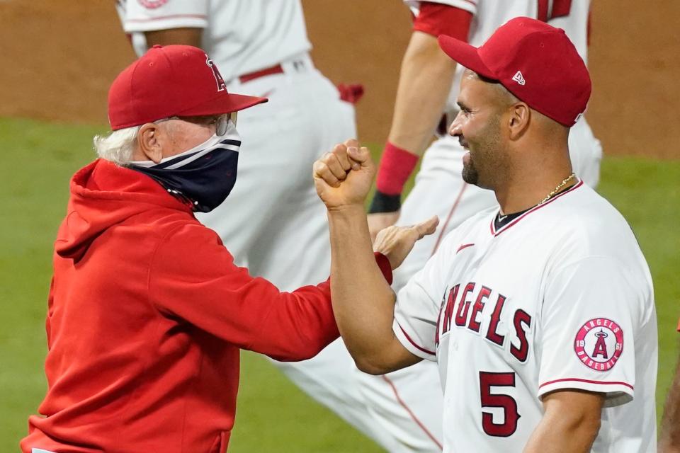 Los Angeles Angels' Albert Pujols, right, celebrates with manager Joe Maddon after a game against the Texas Rangers on Sept. 19 in Anaheim, Calif.