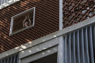 A woman applauds firefighter Elielson Silva playing his trumpet from the top of a ladder for residents cooped up at home, during a lockdown to help contain the spread of the new coronavirus in Rio de Janeiro, Brazil, Sunday, April 5, 2020. Raised to heights of up to 200 feet, Silva has performed all over the city. That includes tourist hot spots that these days are eerily empty -- like Copacabana beach and the base of Sugarloaf Mountain -- and working-class communities Rocinha and Jacarepagua. (AP Photo/Leo Correa)