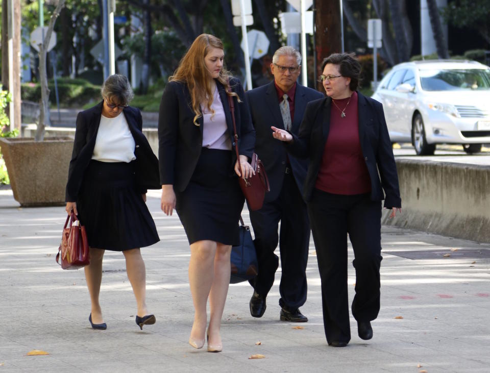 Former Honolulu police chief Louis Kealoha, second from right, and his former deputy city prosecutor wife Katherine Kealoha, right, walk into federal court in Honolulu on Wednesday, May 22, 2019. A trial for what has been described as the biggest corruption case in Hawaii history began Wednesday for the couple, who are accused of conspiring to frame Katherine Kealoha's uncle for a crime he did not commit. The Kealoha's were indicted on charges including conspiracy and obstruction. Federal authorities began investigating the two in 2015 and both stepped down from their jobs as the probe deepened. (AP Photo/Caleb Jones)