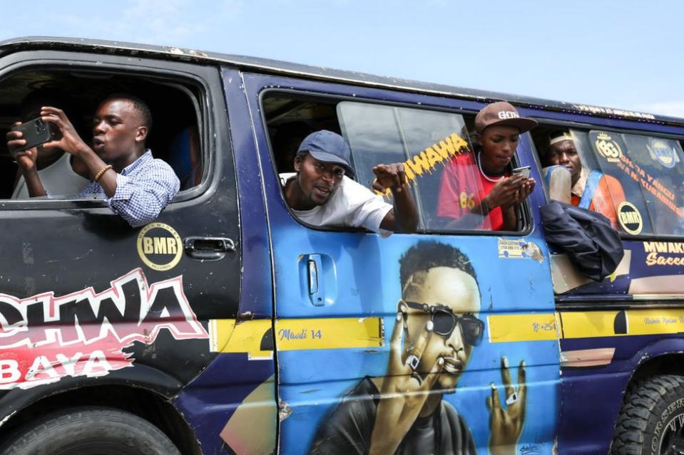 People take photos out of the windows of a minibus in Naivasha.