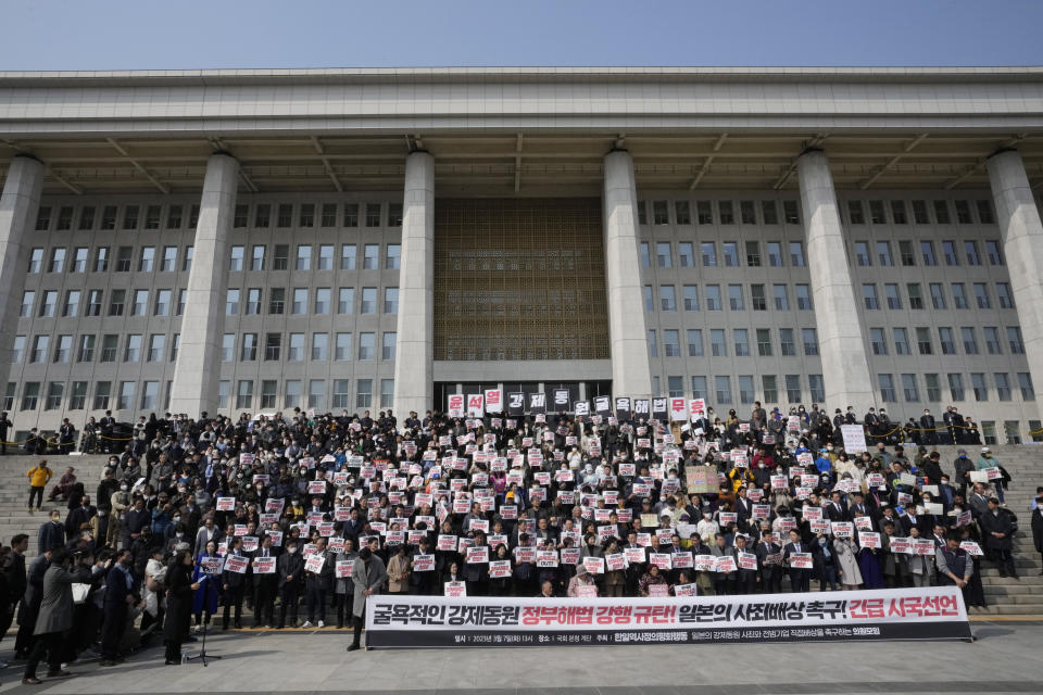 South Korean opposition lawmakers and civic groups stage a rally against the South Korean government's plan over the issue of compensation for forced labors at the National Assembly in Seoul, South Korea, Tuesday, March 7, 2023. South Korean President Yoon Suk Yeol on Tuesday defended his government's contentious plan to use local funds to compensate Koreans enslaved by Japanese companies before the end of World War II, saying it's crucial for Seoul to build future-oriented ties with its former colonial overlord. The signs read "Out with Yoon Suk Yeol's Humiliating Diplomacy." (AP Photo/Ahn Young-joon)