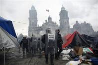 Riot policemen walk in front of the cathedral on the Zocalo after dispersing demonstrators on the Zocalo in Mexico City September 13, 2013. (REUTERS/Tomas Bravo)