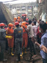 This photograph provided by India’s National Disaster Response Force (NDRF) shows NDRF personnel rescuing a survivor after a residential building collapsed in Bhiwandi in Thane district, a suburb of Mumbai, India, Monday, Sept.21, 2020. (National Disaster Response Force via AP)