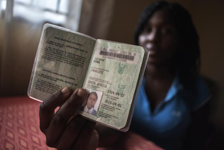 Sharlote Mona, who was born the day that South Africa held its first democratic elections, shows her passport during an interview with Agence France-Presse in the Olievenhoutbosch township, on the outskirts of Centurion, South Africa