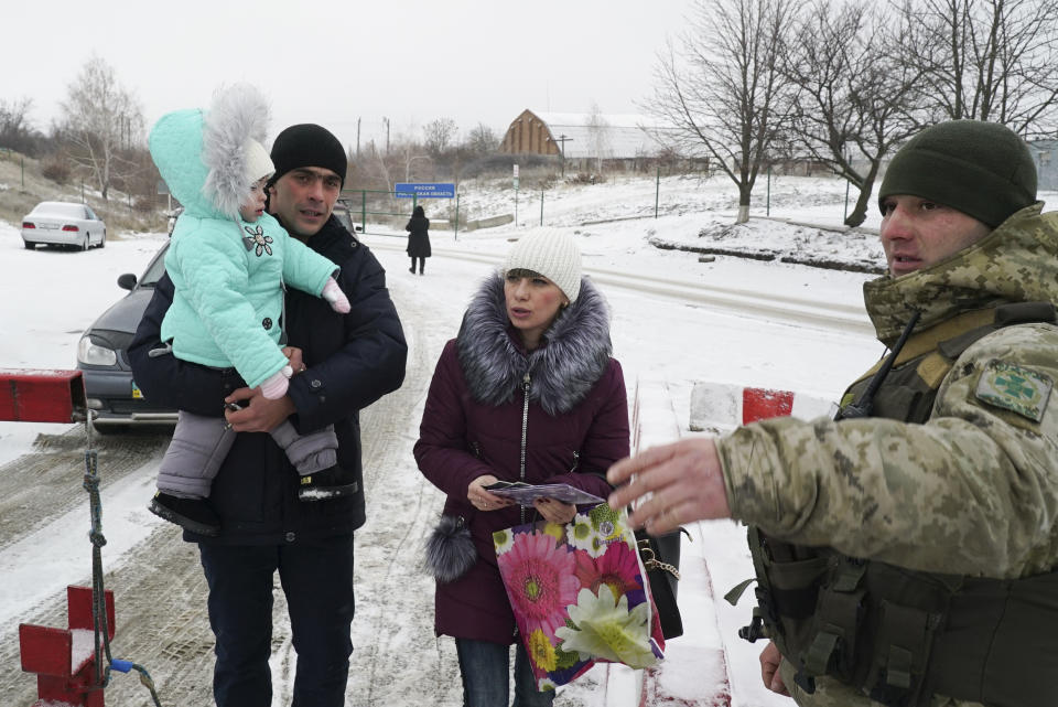 A Ukrainian family wait to cross the border from Russia to Ukrainian side of the Ukraine - Russia border in Milove town, eastern Ukraine, Sunday, Dec. 2, 2018. On a map, Chertkovo and Milove are one village, crossed by Friendship of Peoples Street which got its name under the Soviet Union, and on the streets in both places, people speak a mix of Russian and Ukrainian without turning choice of language into a political statement. (AP Photo/Evgeniy Maloletka)