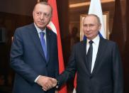 Russian President Vladimir Putin and his Turkish counterpart Tayyip Erdogan shakes hands during their meeting on sideline of the Libya summit in Berlin