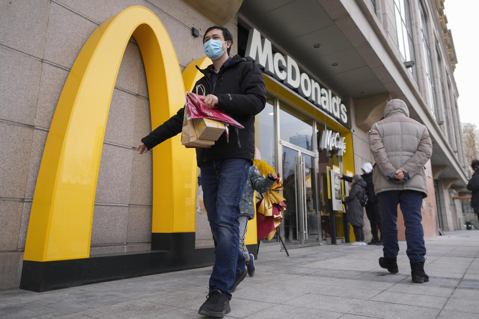 A man carries his take way McDonald's foods as people take order at a machine at a newly opened McDonald's restaurant on Sunday, Dec. 24, 2023. It was tumultuous 2023 for the Chinese economy. Some of the world's biggest brands said they were weighing, or already have decided, to shift manufacturing away from China amid unease about security controls, government protection of their Chinese rivals and Beijing's wobbly relations with Washington. But there was at least one bright spot for Beijing amid all the tough news about declining foreign investment: American fast food companies have announced a surge of investment in a market of 1.4 billion people. KFC, McDonald's and Starbucks are among companies in recent months that have announced plans for major investment in China. (AP Photo/Andy Wong)