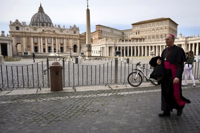 A prelate walks outside St Peter’s Square after the Vatican erected a new barricade at the edge of the square 