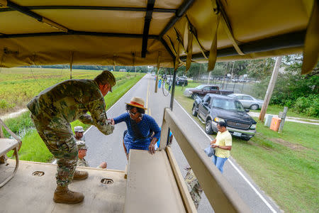 U.S. Army Brig. Gen. Jeff Jones, the South Carolina National Guard Assistant Adjutant General for Army, assists soldiers as they transport community members into flooded areas to retrieve critical items from their homes as the water continues to rise as a result of Hurricane Florence in their neighborhoods, in the town of Bucksport, South Carolina, U.S. September 24, 2018. Picture taken September 24, 2018. Staff Sgt. Jorge Intriago/U.S. Army National Guard/Handout via REUTERS