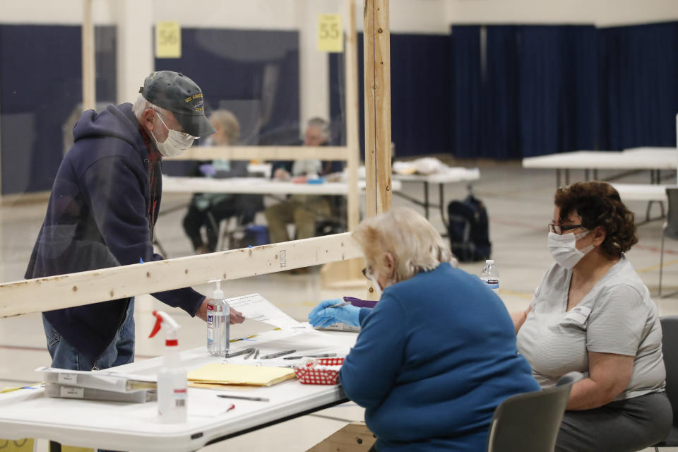 A man checks in to cast his ballot at a Democratic presidential primary election at the Kenosha Bible Church gym in Kenosha, Wisconsin, on April 7, 2020.