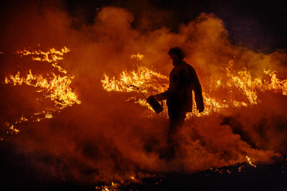 A firefighter works to douse flames of a bushfire in Australia. 