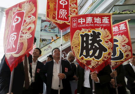 Property sales agents from one of the biggest agent companies in Hong Kong carry banners with a Chinese character "win", during the promotion of a property development in Hong Kong March 20, 2015. REUTERS/Bobby Yip