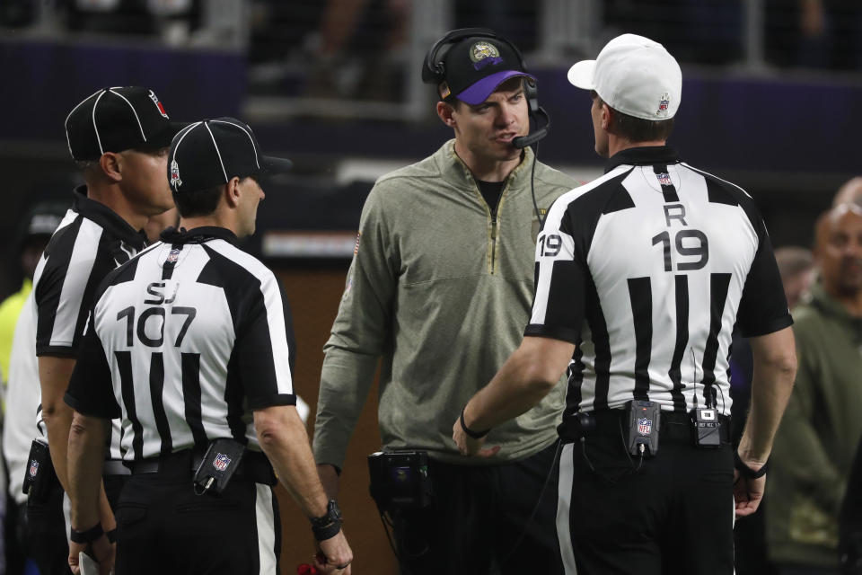Minnesota Vikings head coach Kevin O'Connell, center, talks with referee Clay Martin (19) during the second half of an NFL football game against the Dallas Cowboys, Sunday, Nov. 20, 2022, in Minneapolis. (AP Photo/Bruce Kluckhohn)