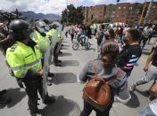 Police face off with merchants blocking a street protesting for the right to work under lockdown, in Bogota, Colombia, Friday, April 16, 2021. A lockdown was reimposed for the weekend after a spike in COVID-19 cases in the Colombian capital, the pandemic’s third peak so far. (AP Photo/Fernando Vergara)