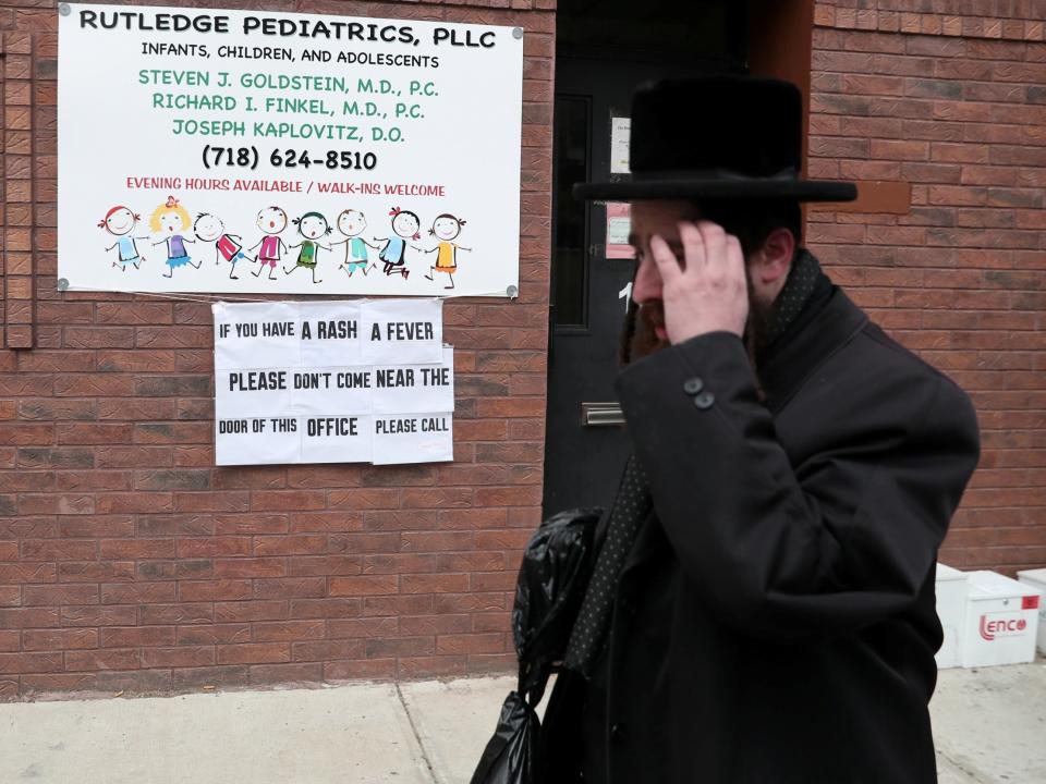 Last month, a traveller raising money for charity in Brooklyn's ultra-Orthodox Jewish community drove through the night to Detroit \- his next fundraising stop. He felt sick en route and saw a doctor when he got there. But the doctor, who had never seen measles, misdiagnosed the man's fever and cough as bronchitis.Over the next two weeks, the traveller would become Michigan's Patient Zero, spreading the highly contagious respiratory virus to 39 people as he stayed in private homes, attended synagogue daily and shopped in kosher markets. His case offers a cautionary tale about how easily one of the most infectious pathogens on the planet spreads within close-knit communities - especially those whose members live, work and socialize outside the mainstream."Every one of our cases has had a link to the initial case," said Leigh-Anne Stafford, health officer for Oakland County, a Detroit suburb where all but one case was reported.In the past five years, 75 percent of measles cases reported to the Centers for Disease Control and Prevention occurred in various insular communities, among them the Amish in Ohio, the Somali community in Minnesota, Eastern European groups in the Pacific Northwest and the ultra-Orthodox Jewish community in New York.In the current outbreak, the New York contagion has spread through Patient Zero and other travellers to predominantly ultra-Orthodox communities in Westchester and Rockland Counties in New York; Oakland County in Michigan, and Baltimore County in Maryland. On Friday, Connecticut officials said an adult contracted measles while visiting Brooklyn in late March. New Jersey officials are investigating possible links between 11 cases in the Ocean County area and those in New York."What's similar about all of these communities is that they live in proximity to each other and spend a lot of their time interacting with each other," said Daniel Salmon, a professor of international health at the Johns Hopkins Bloomberg School of Public Health and director of the school's Institute for Vaccine Safety. "That's what matters. Measles doesn't care what your cultural heritage is."Many of these communities are wary of government, avoid television and the Internet, and often rely on their own clinicians for medical care. In such a void, anti-vaccine misinformation has sometimes gained a foothold, deterring parents from fully vaccinating their children.The traveller had come from Israel last November to Brooklyn, the epicentre of a measles outbreak, and stayed for about two months before going on to the Detroit area in early March, said Russell Faust, Oakland County's medical officer. The man, whom Michigan health officials are not identifying, told them he was visiting ultra-Orthodox communities in the United States to raise money for charity.Feverish and coughing after his arrival, he saw a doctor, who prescribed antibiotics.When the man called back to complain of a rash the next day, the doctor thought he was having an allergic reaction. But after the doctor thought more about it, he worried about the possibility of measles and decided to leave a voice message for the health department with the man's cellphone number. Health officials jumped on the case - but couldn't reach the man because of a problem with his cellphone.They turned to Steve McGraw, head of Oakland emergency medical services and longtime member of the Detroit-area Hatzalah, the ultra-Orthodox community's emergency medical response group, an all-volunteer effort with deep ties to many families. Mr McGraw alerted rabbinical leaders, then jumped in his car and drove to the area the traveller was supposed to be staying to look for the man's rental car, a blue sedan, knowing it would stand out among the minivans used by virtually every family.Hatzalah members and rabbinical leaders also mobilised to search for the traveller, who was staying in a neighbourhood guesthouse. When they found him a few hours later, the traveller was stunned. He told Mr McGraw and the rabbi who found him that they had to be wrong since he believed he had had the measles."There is only one disease, and you have it," Mr McGraw recalled saying, as one rabbi translated into Hebrew. "He put his head down and was very emotional. I could tell from the look on his face that he was devastated. He was doing the math in his head," counting all the people he had been in contact with, Mr McGraw said.The traveller, as it turned out, had had hundreds of contacts with community members that health officials needed to trace. He had stayed mostly in private homes in the areas of Oak Park and Southfield. He had visited synagogues three times a day to pray and study and frequented kosher markets and pizza parlours, among 30 locations in one week."This guy was walking around all over the community and contagious," Mr McGraw said. "We knew we had a really significant exposure."Measles virus is so infectious that if an unvaccinated person walks through a room up to two hours after someone with measles has left, there's a 90 percent chance the unvaccinated person will get sick. People can spread measles for four days before and four days after the telltale rash. Because measles is so infectious, at least 96 percent or more of a community need to be vaccinated to prevent risk of outbreak.On 13 March, blood tests confirmed the traveller's measles. The strain matched the genetic fingerprint of the New York City outbreak, Mr McGraw said. The same day, health officials alerted the public.To get information out to the ultra-Orthodox community, health officials used its internal messaging system known as a calling post. Recorded voice messages ring on about 1,200 mobile phones. Mr McGraw recorded a message that rabbinical leaders approved for delivery, the first of several that provided information about the disease and vaccination clinics.Over the next few weeks, Janet Snider, a paediatrician for many ultra-Orthodox families, and Gedalya Cooper, an emergency medicine doctor, both members of the Hatzalah, visited people in their homes to diagnose and test them for measles.The Council of Orthodox Rabbis of Greater Detroit issued an unequivocal statement, saying Jewish law obligated every community member to be "properly and fully vaccinated" according to the CDC. The agency recommends children get two measles, mumps and rubella (MMR) doses, starting with the first dose at age 12 through 15 months and the second dose at age 4 through 6 years."In order to protect and safeguard each and every individual within the larger community, every individual, family and institution must take the necessary precautions against anyone who chooses not to be vaccinated," the statement said.The Hatzalah and rabbinical leaders helped the health department set up three clinics at one synagogue, immunising nearly 1,000 people in one week. As of early April, health officials have given more than 2,100 vaccinations. Vaccine refusal does not appear to be a major factor in the Oakland County cluster, officials said.In Michigan, at least, the close collaboration between health officials and the religious community appears to have controlled the spread of the disease, which can cause severe complications including deafness, pneumonia, brain damage and death.Now, with 555 measles cases in 20 states - the highest in five years - other localities are looking at that model. Hatzalah groups in other parts of the country are reaching out to county officials for advice on boosting vaccination within the ultra-Orthodox community, Mr Faust said.Oakland County had something else going for it: Measles outbreaks typically start with children. But Patient Zero had spent most of his time with adults, and most of the 39 cases are in adults. Many adults who got sick had believed they were immune, as some had been told they had the disease as children or were vaccinated."There are a fair number of non-immunised or under-immunised adults," said Mr Faust, the medical officer. Some of the adults infected also were born before 1957, when most people caught measles and are thought to have natural immunity.Officials said that the risk remains high for those who are unvaccinated or under-vaccinated and who travel to communities here or abroad where measles cases are raging.Gaps in vaccination coverage have led to a 20-year high in measles cases in Europe. Major outbreaks also are taking place in parts of the Middle East, Southeast Asia and Japan. More than 1,200 people have died in Madagascar. With spring break and summer vacations approaching, travellers visiting European countries with outbreaks, such as France and Italy, have a much higher chance of bringing infections back to "islands or pockets of vulnerability," said Saad Omer, an infectious disease expert at Emory University."Measles is a very unforgiving disease," he said. "Even if most people are vaccinated, that number may not be high enough."The Washington Post