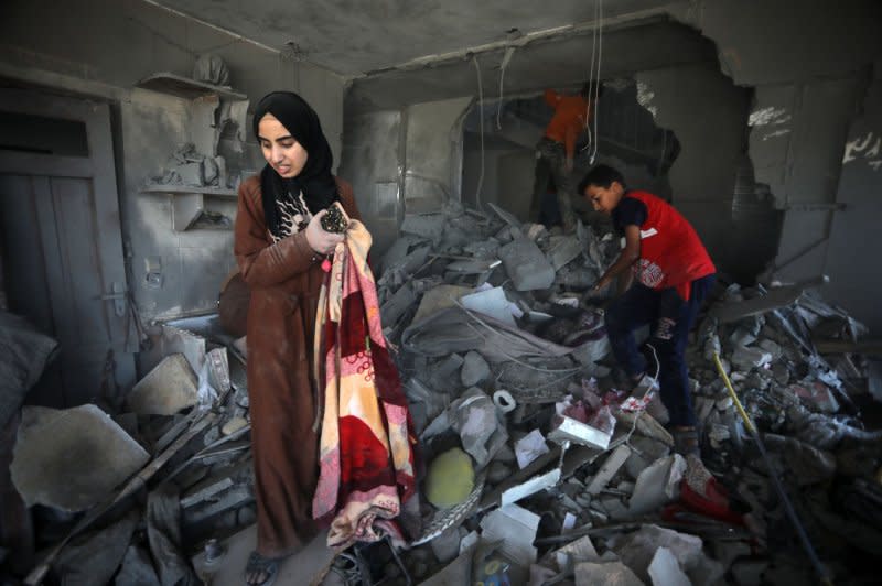 Palestinians take what is left of their belongings from their destroyed house following overnight Israeli airstrikes in town of Rafah, southern Gaza Strip, on April 20. U.S. President Joe Biden and Israeli Prime Minister Benjamin Netanyahu spoke on the phone on Sunday where Biden "reiterated his clear position" on an invasion of Rafah, which the United States in the past has called a "red line." Photo by Ismael Mohamad/UPI