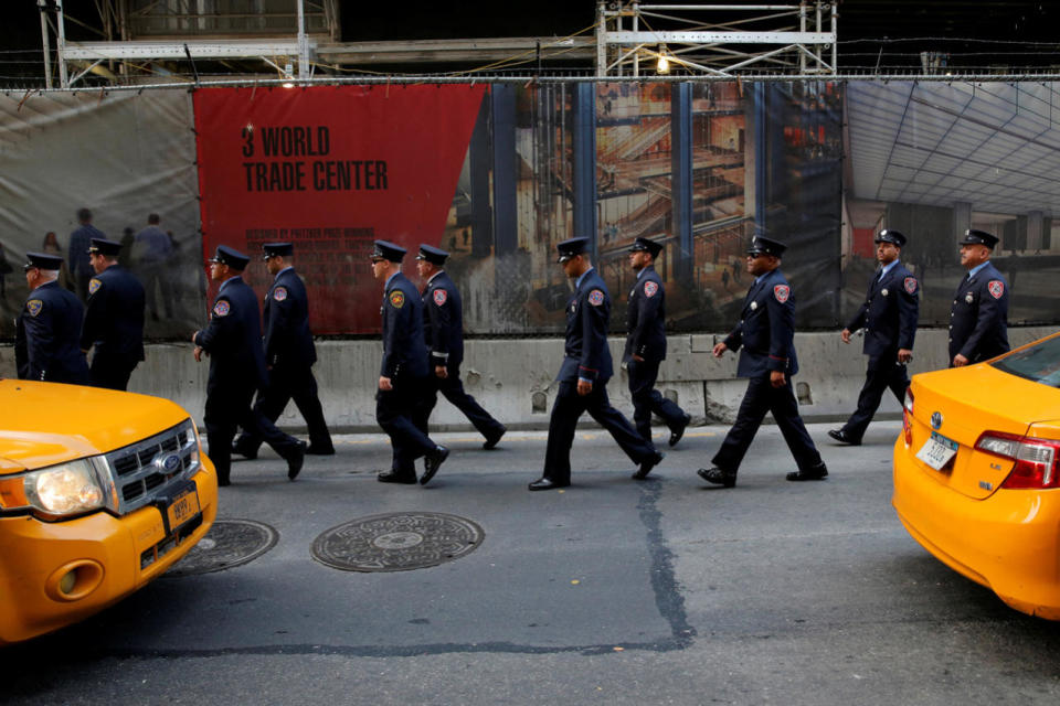 Firefighters arrive for a memorial service at the World Trade Center complex