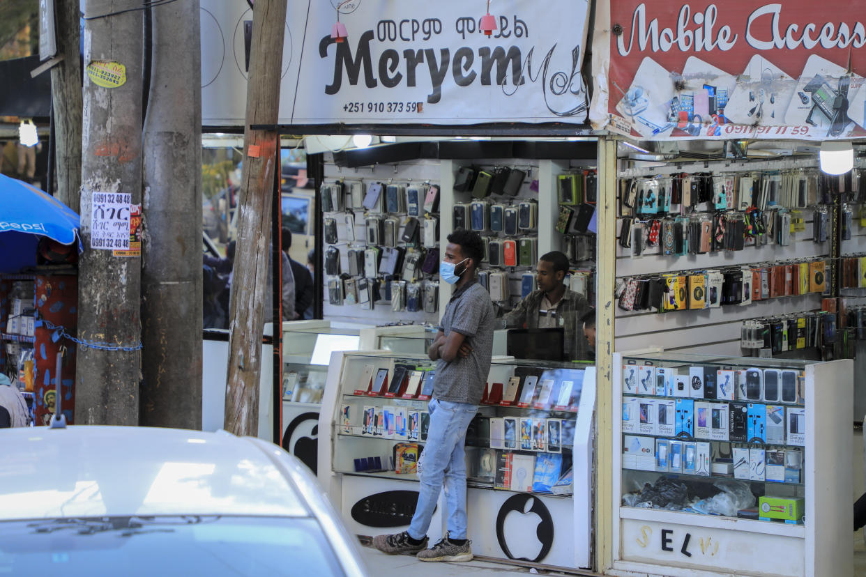 A man stands outside a mobile phone accessory shop in the Piazza old town area of the capital Addis Ababa, Ethiopia Thursday, Nov. 4, 2021. Urgent new efforts to calm Ethiopia's escalating war are unfolding Thursday as a U.S. special envoy visits and the president of neighboring Kenya calls for an immediate cease-fire while the country marks a year of conflict. (AP Photo)