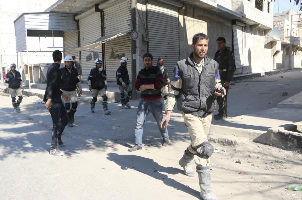 Rescuers and people walk at a site hit by what activists said was a barrel bomb dropped by forces loyal to Syria's President Bashar al-Assad in Masaken Hanano in Aleppo February 17, 2014. REUTERS/Hosam Katan (SYRIA - Tags: POLITICS CIVIL UNREST CONFLICT)