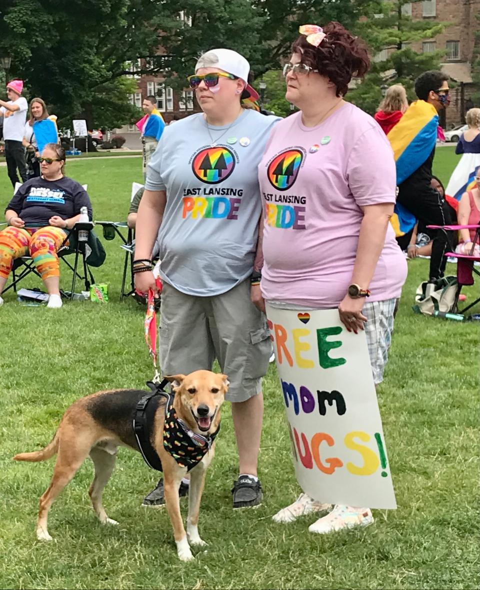 Kat and Carrie Monroe of Perry with their dog Radar outside the Michigan State Capitol building before the 2022 Michigan Pride Rally on June 26, 2022.