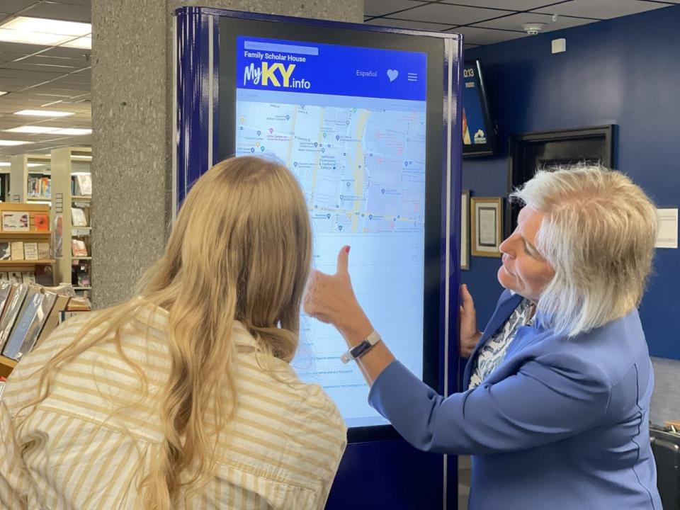 Cathe Dykstra (right) and Megan Eldridge, Family Scholar House employees, give a demonstration on how to use the MyKy.info kiosks.