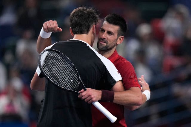 Novak Djokovic, right, embraces Jakub Mensik 