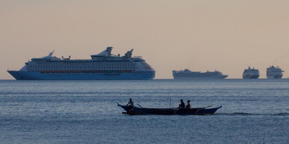 FILE PHOTO: Fishermen sail past a group of cruise ships anchored in Manila Bay as its crew members undergo quarantine amid the coronavirus disease (COVID-19) outbreak, in Manila, Philippines, May 8, 2020. REUTERS/Eloisa Lopez