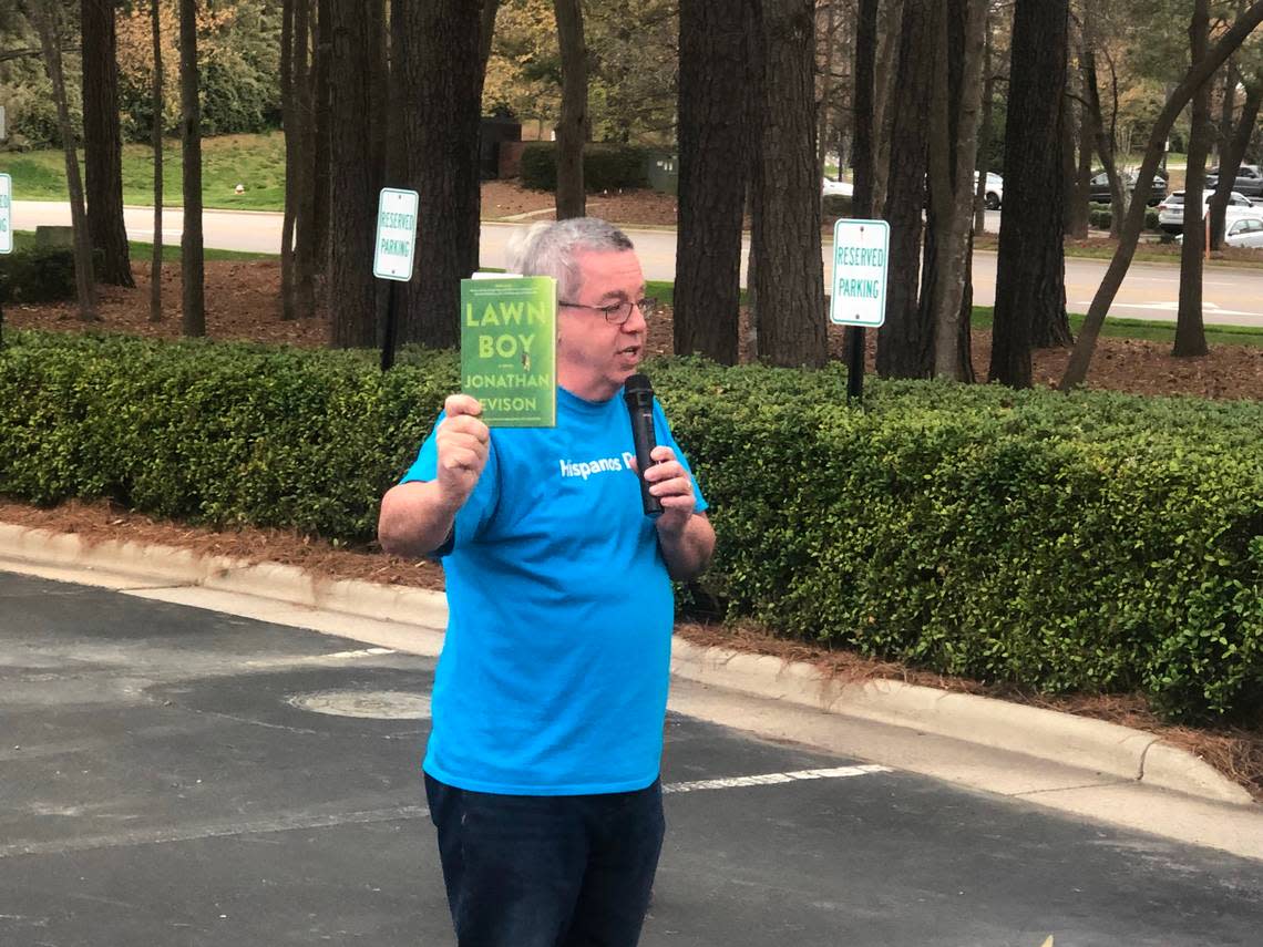 Gil Pagan holds up a copy of “Lawn Boy” by Jonathan Evison at a protest outside the Wake County school board meeting in Cary, N.C., on April 5, 2022. Pagan says the book should not be allowed to be read by minors.
