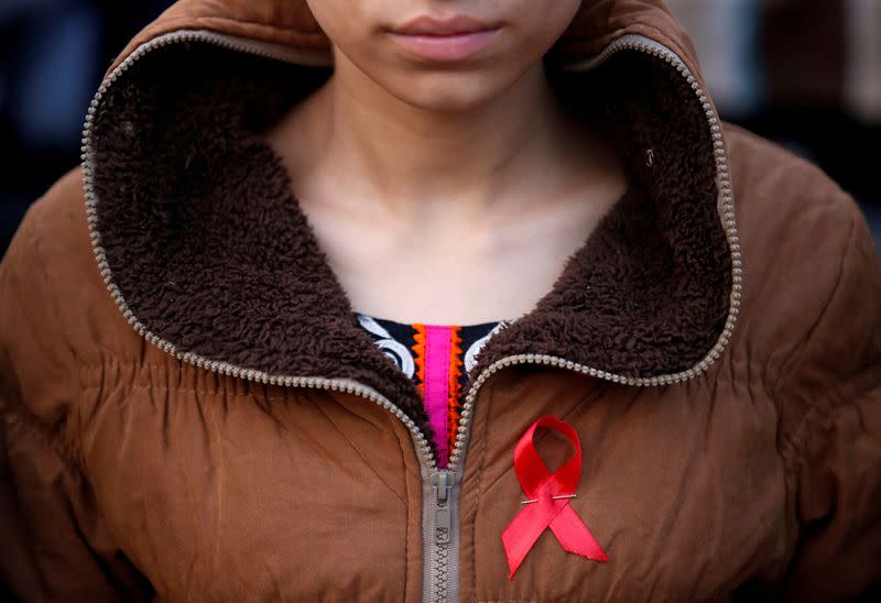 FILE PHOTO: A participant with a red ribbon pin takes part in HIV/AIDS awareness campaign ahead of World Aids Day, in Kathmandu