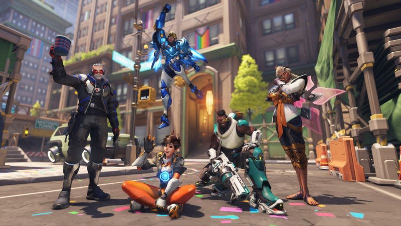 Soldier 76, Tracer, Pharah, Baptiste, and Lifeweaver are seen standing in the Midtown street with Pride decorations surrounding them.