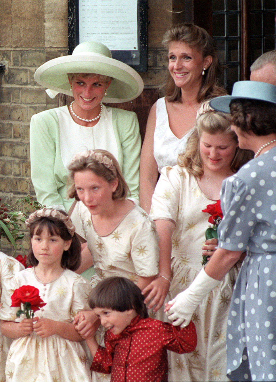 PA NEWS PHOTO 30/8/91  DIANA, THE PRINCESS OF WALES AT THE WEDDING OF HER FORMER FLAT-MATE VIRGINIA PITMAN TO BANKER HENRY CLARKE AT CHRIST CHURCH IN CHELSEA, LONDON. WITH HER IS ANOTHER OF HER OLD FLAT-MATES SOPRANO CAROLYN BARTHOLOMEW   (Photo by Martin Keene - PA Images/PA Images via Getty Images)