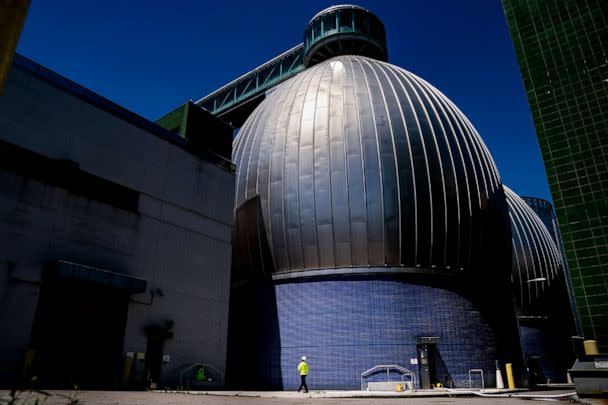 PHOTO: A worker walks alongside the Newtown Creek Wastewater Treatment Plant's array of digester eggs, Aug. 12, 2022, in New York City.  (John Minchillo/AP)