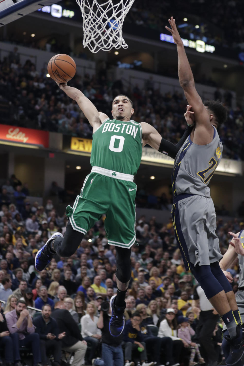 Boston Celtics forward Jayson Tatum (0) goes up for a dunk over Indiana Pacers forward Thaddeus Young (21) during the second half of an NBA basketball game in Indianapolis, Friday, April 5, 2019. (AP Photo/Michael Conroy)